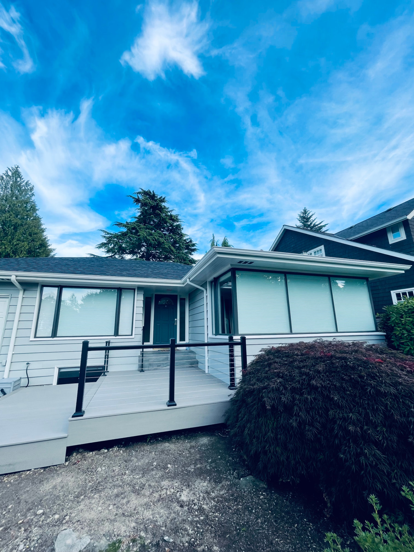 Same single-story house finished with crisp light gray siding and dark trim windows.